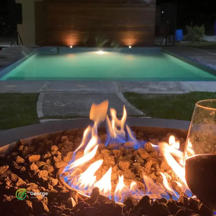 Fogata encendida junto a la alberca climatizada al anochecer